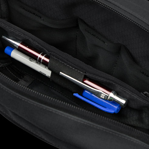 Close-up of the interior of the Condor Tech Pouch - MultiCam Black, showing two pens and a blue pen cap organized in dedicated pen slots.